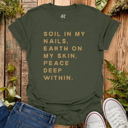 Green t-shirt with text on a wooden background with plants