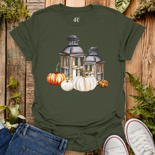 Green t-shirt with lantern and pumpkin design on a wooden background