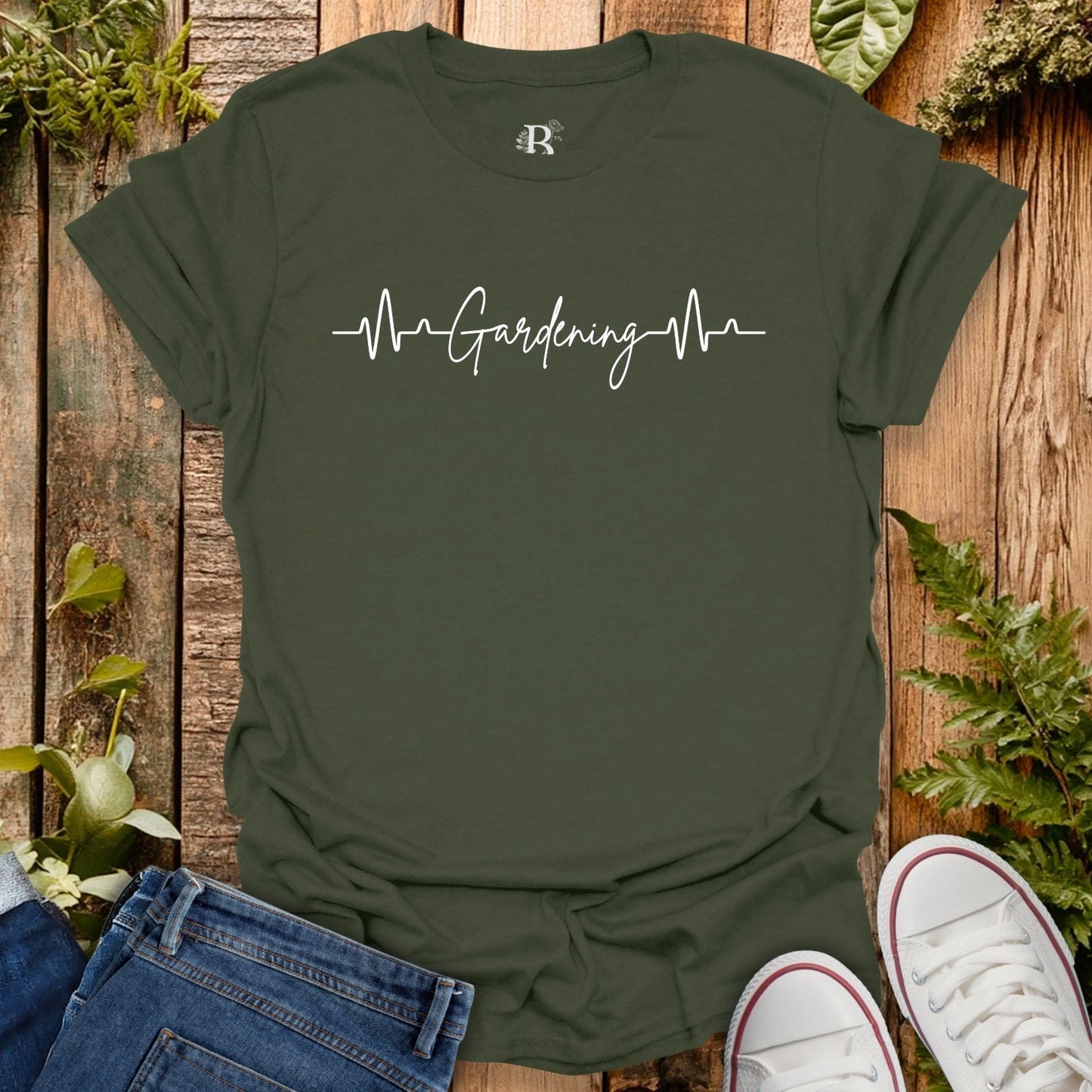 Green t-shirt with 'Gardening Heartbeat' text on a wooden background with plants.