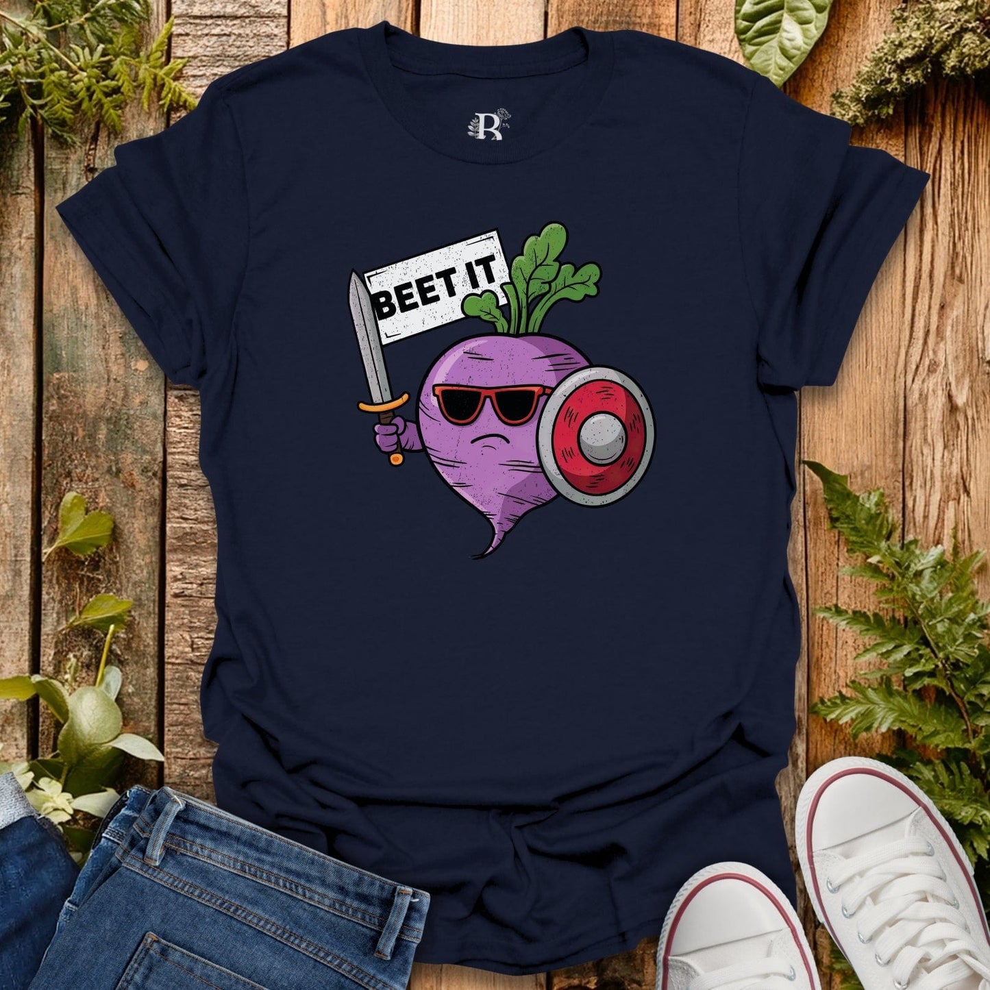 Navy blue t-shirt with a graphic design of a beet holding a sword and sign on a wooden surface.