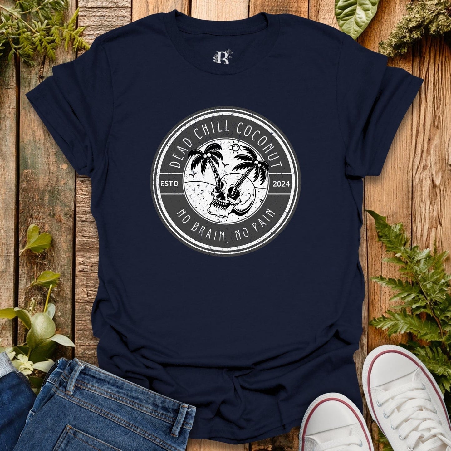 Navy blue t-shirt with a graphic design on a wooden surface with plants.