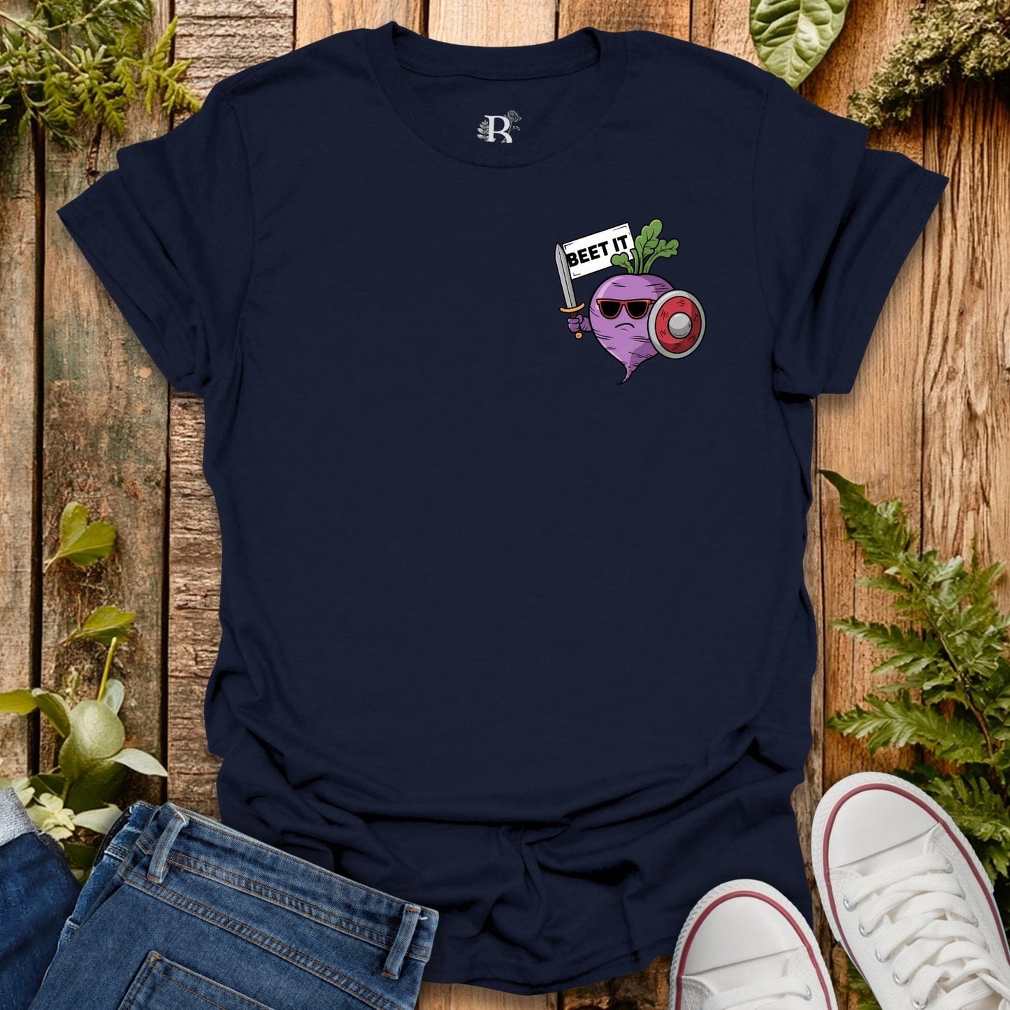 Navy blue t-shirt with a graphic design on a wooden surface with plants.