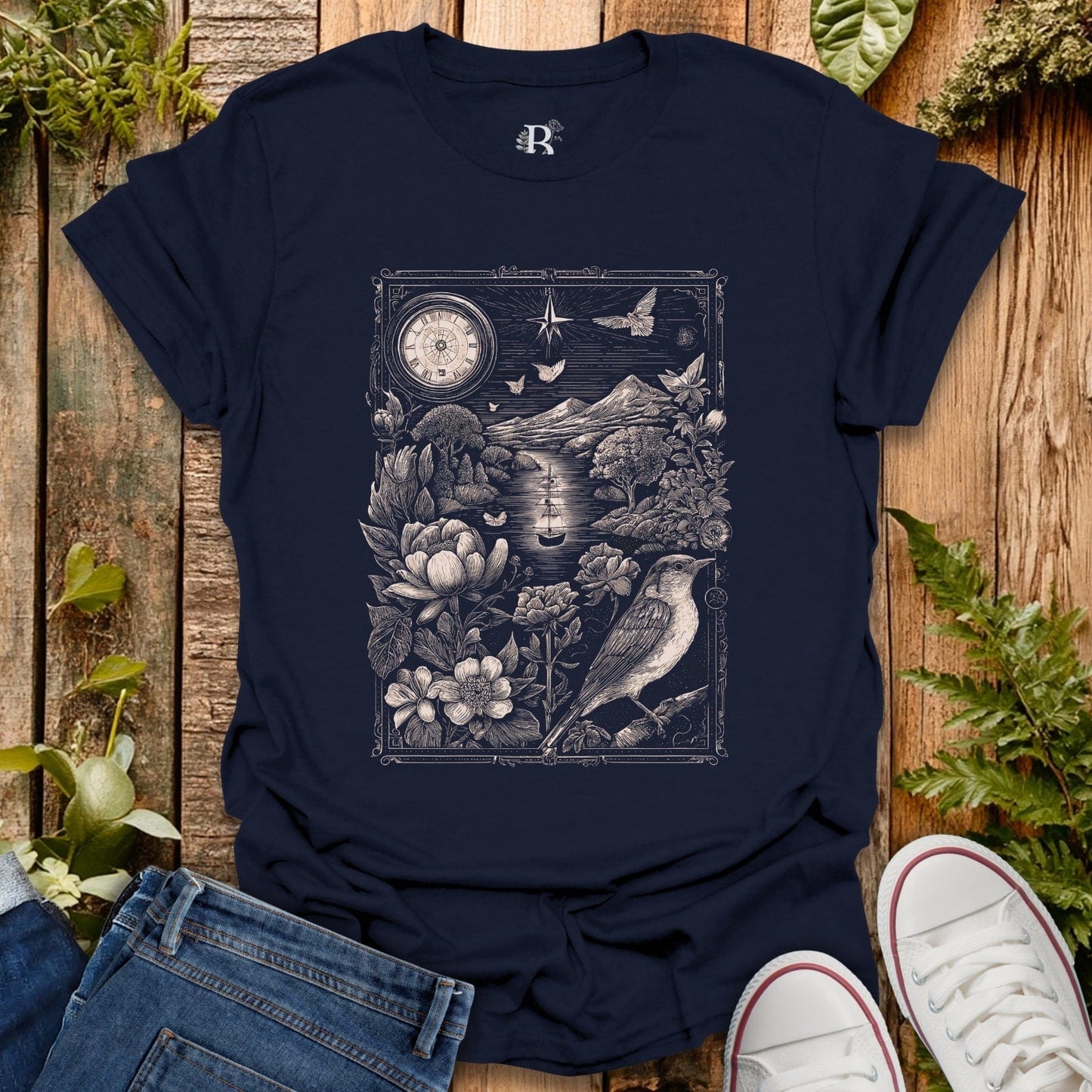 Navy blue t-shirt with nature-themed design on a wooden surface with plants.