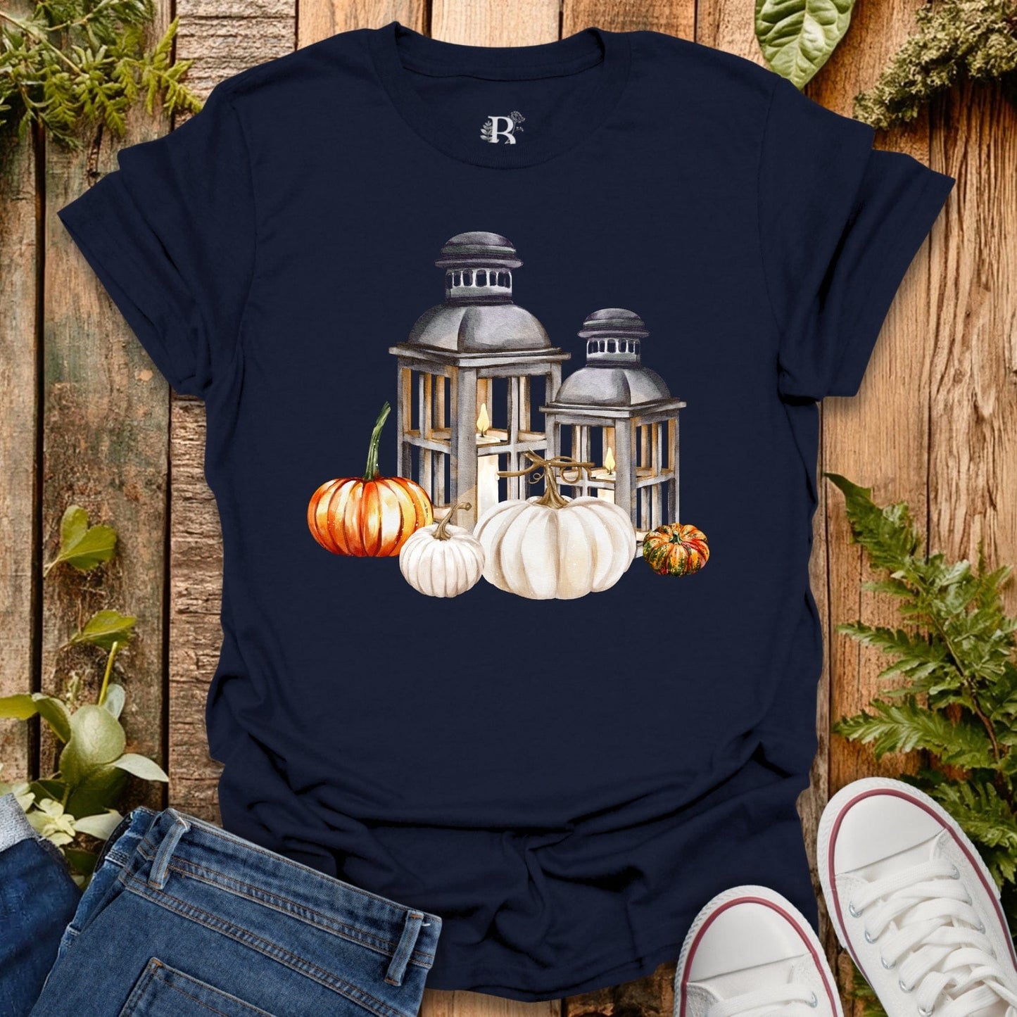 Navy blue t-shirt with pumpkins and lantern design on a wooden background