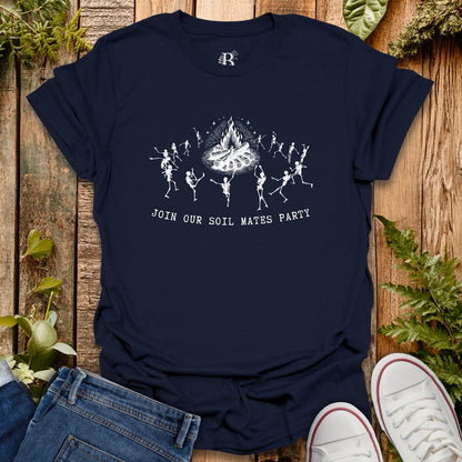 Navy blue t-shirt with skeleton design and text on a wooden surface with plants.