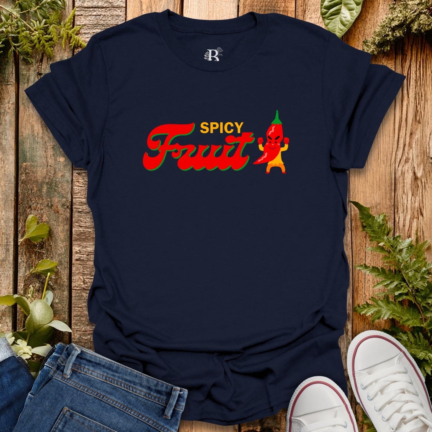 Navy blue t-shirt with 'Spicy Fruit' graphic design on a wooden surface with jeans and white sneakers.