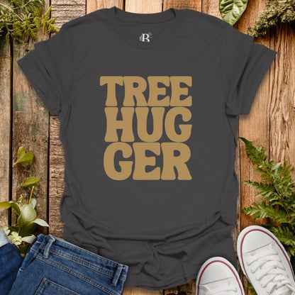 Black t-shirt with 'TREE HUGGER' text on a wooden surface with plants.
