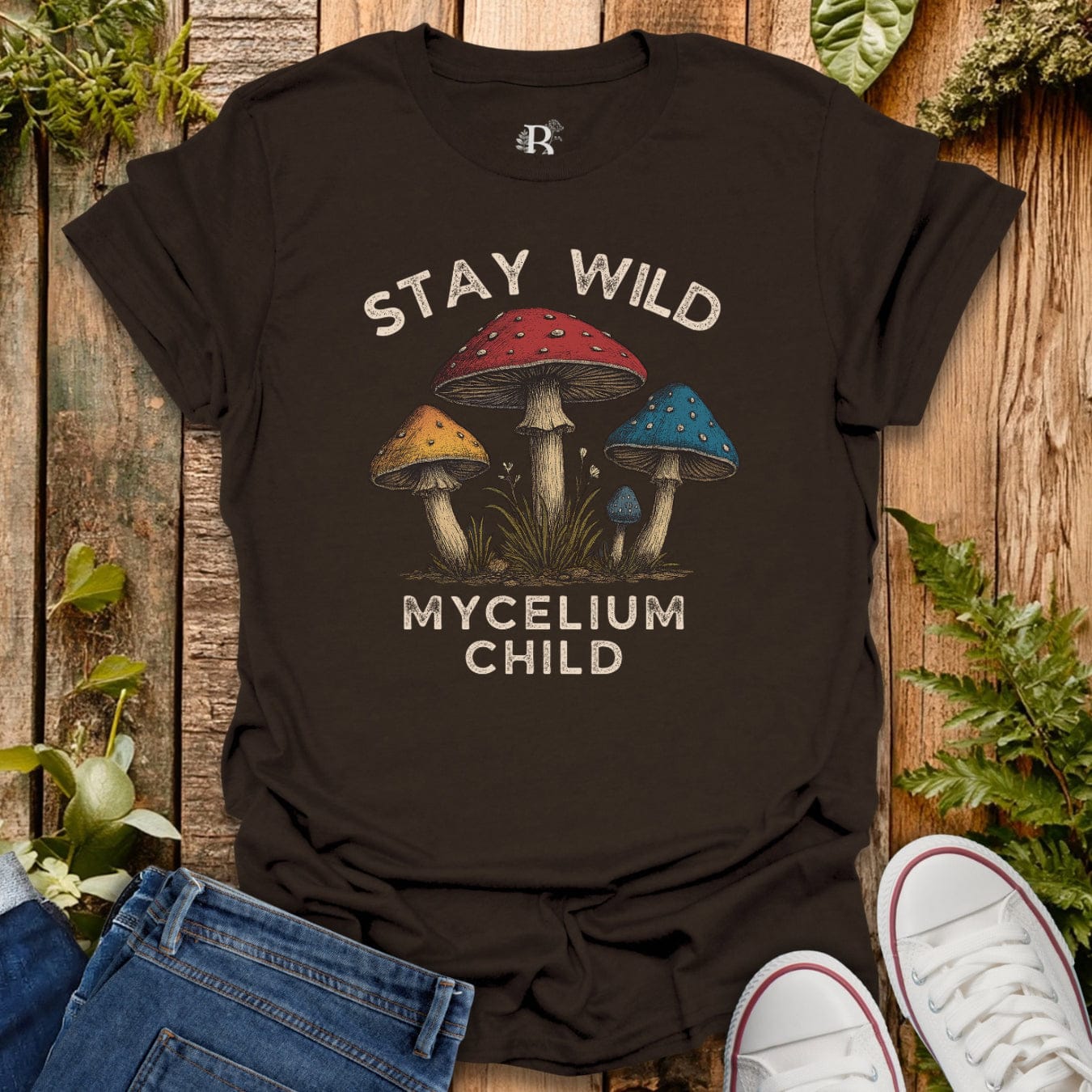 Brown t-shirt with text “stay wild mycelium child” and mushroom graphic.