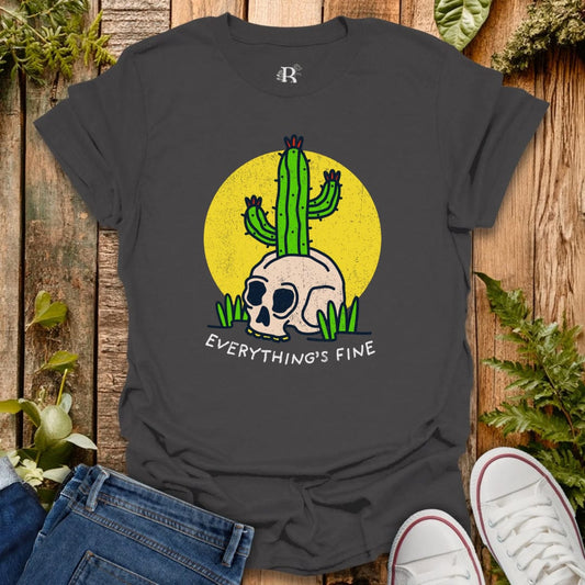 Black t-shirt with a skull and cactus design and 'Everything's Fine' text on a wooden surface.
