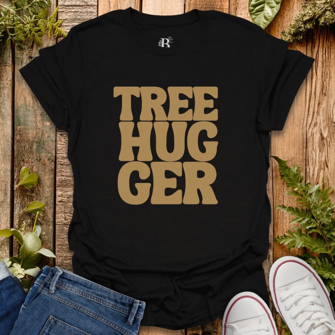 Black t-shirt with 'TREE HUGGER' text on a wooden surface with plants.