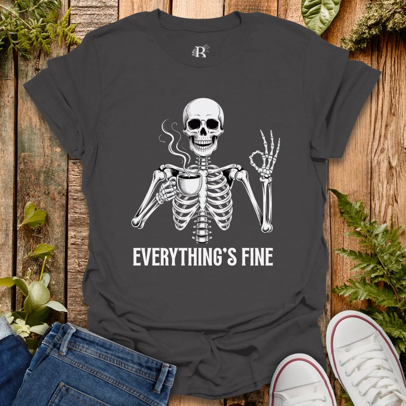 Gray t-shirt with a skeleton graphic and 'EVERYTHING'S FINE' text on a wooden surface.