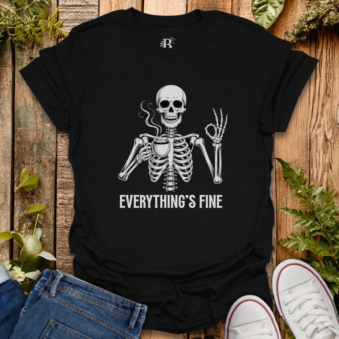 Black t-shirt with a skeleton graphic and 'EVERYTHING'S FINE' text on a wooden surface with plants.