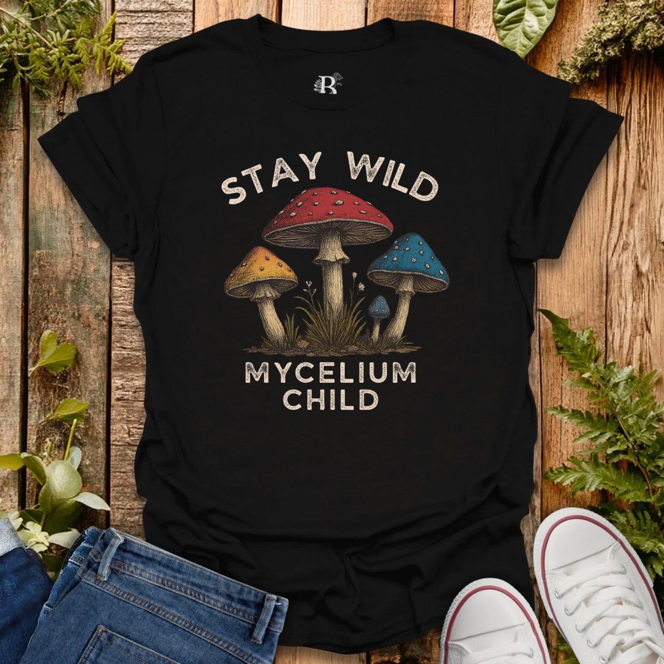 Black t-shirt with text “stay wild mycelium child” and mushroom graphic.