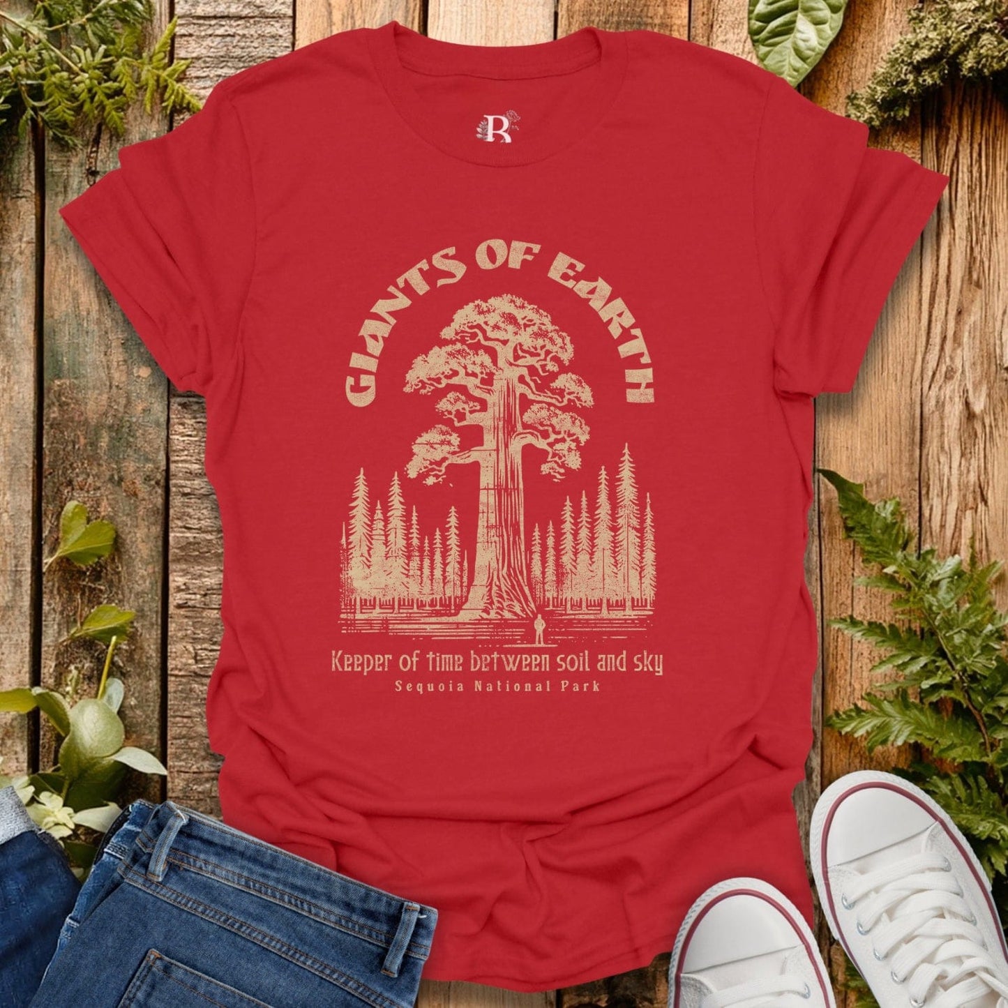 Red t-shirt with 'Giants of Earth' design on a wooden background