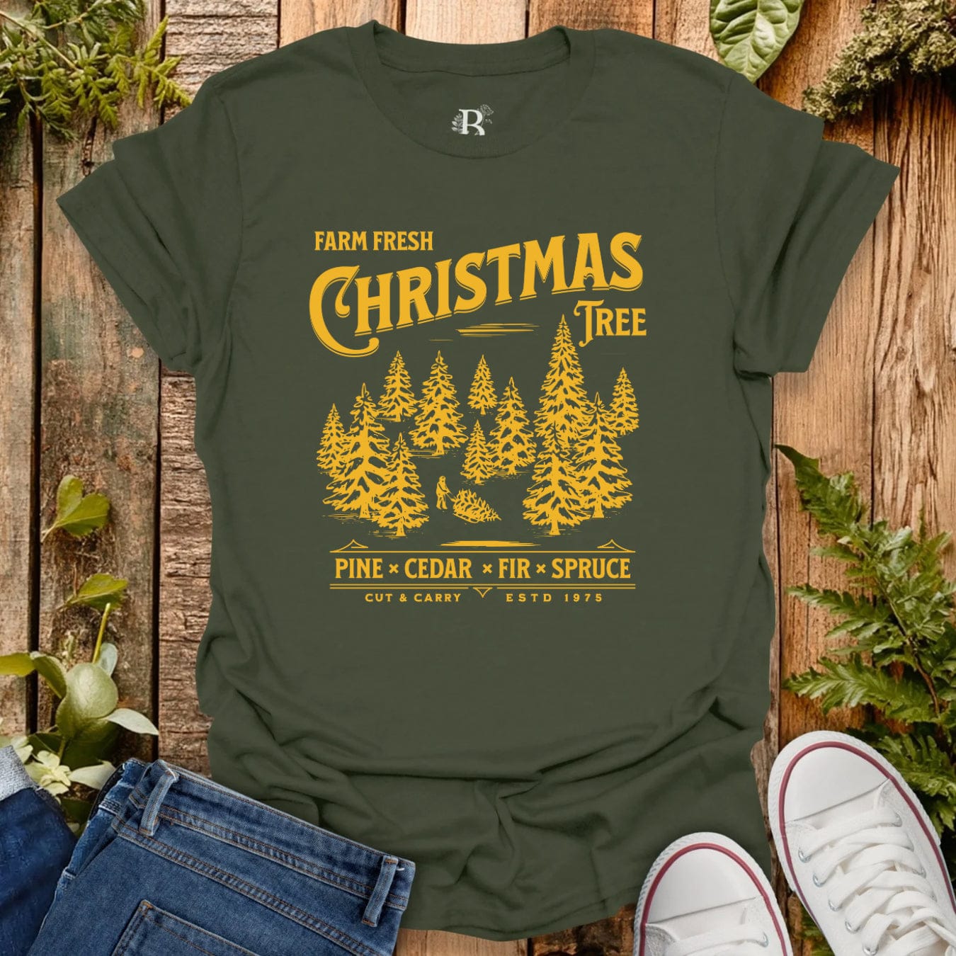 Green t-shirt with yellow Christmas tree design on a wooden background