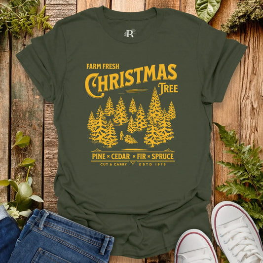 Green t-shirt with yellow Christmas tree design on a wooden background