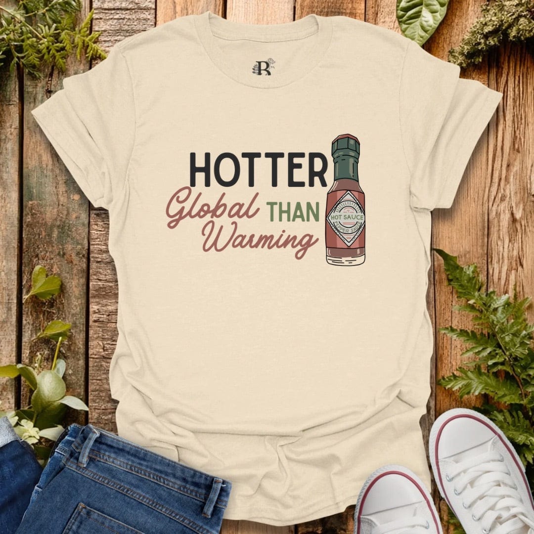 Beige tee with text “hotter that  global warming” and bottle of hot sauce graphic .