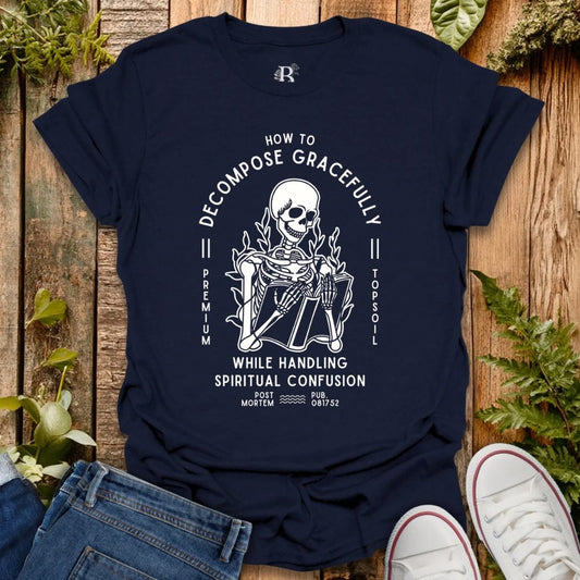 Navy blue t-shirt with a skeleton graphic and text on a wooden surface with plants.