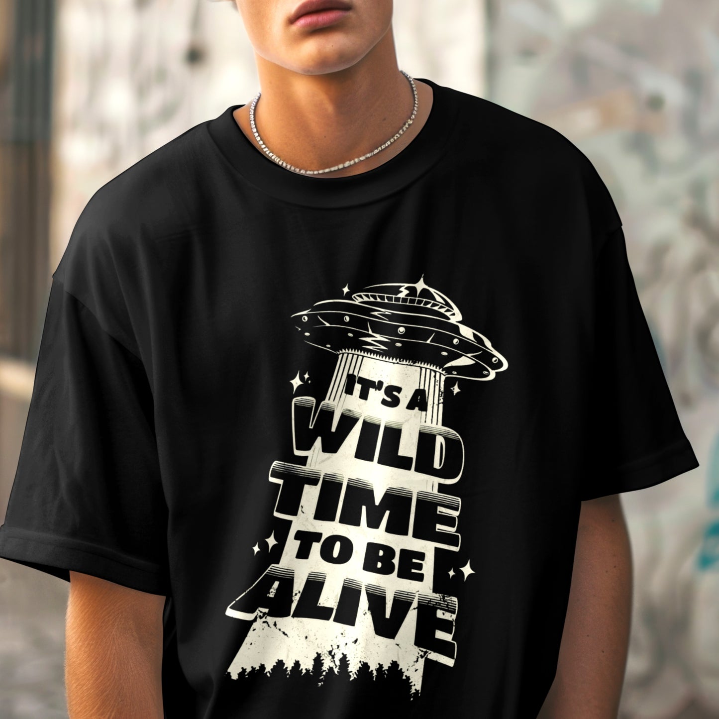 Man wearing black T-shirt with UFO graphic design.